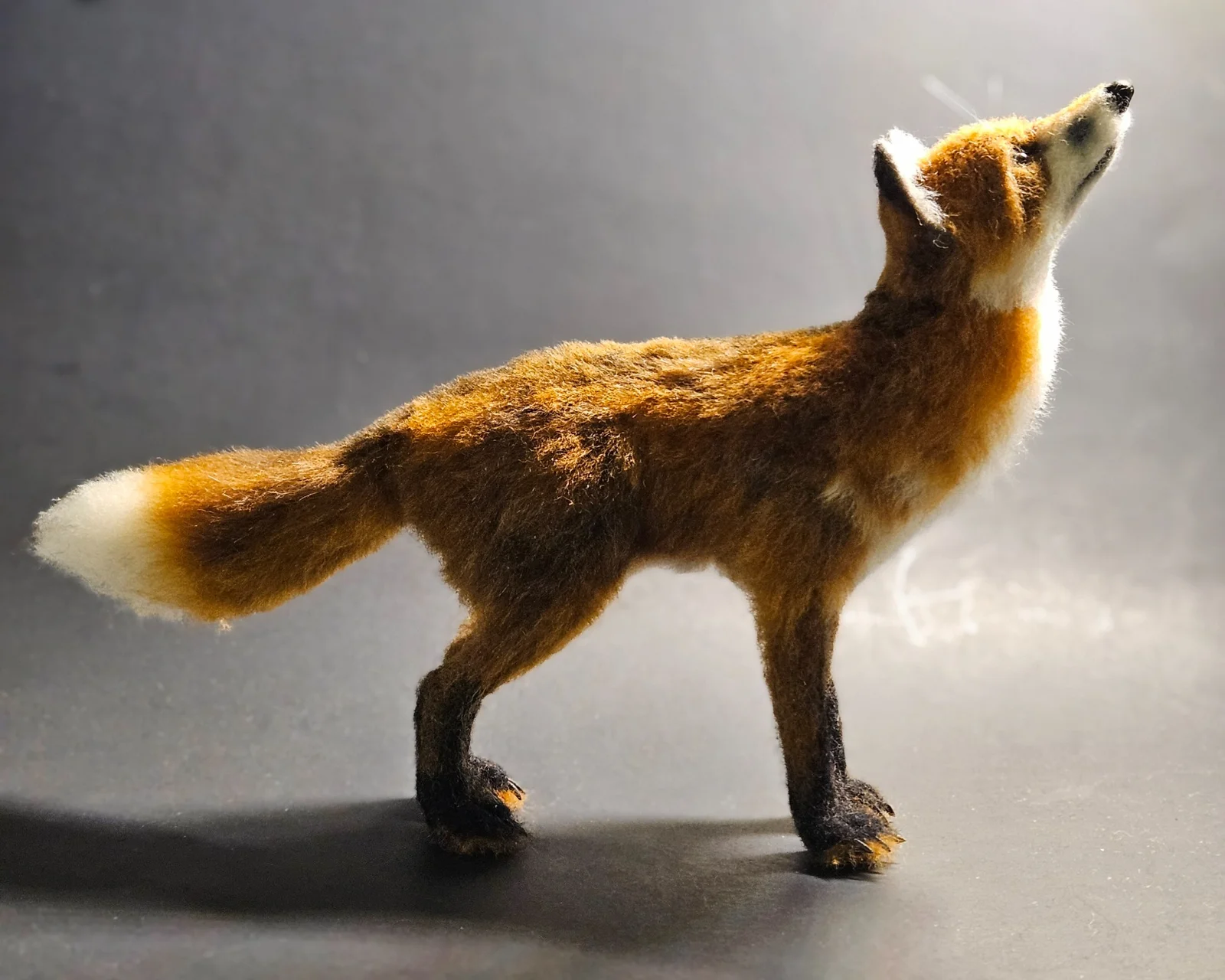Needle-felted red fox with raised muzzle and white-tipped tail by Irina Hughes